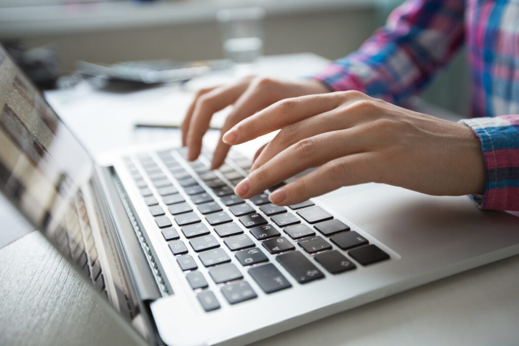 O que é CNAE: mão de mulher digitando em notebook